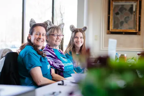 Three women in Birchway Niagara t-shirts wearing wolf ears